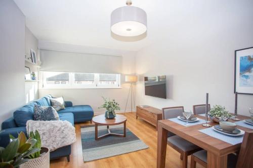 a living room with a blue couch and a table at Stylish 2-Bed Apartment Near Glasgow Green in Glasgow