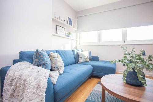 a blue couch in a living room with a table at Stylish 2-Bed Apartment Near Glasgow Green in Glasgow