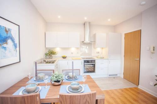 a kitchen with a table and a dining room at Stylish 2-Bed Apartment Near Glasgow Green in Glasgow