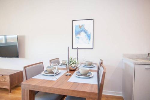 a dining room table with chairs and a table and a kitchen at Stylish 2-Bed Apartment Near Glasgow Green in Glasgow