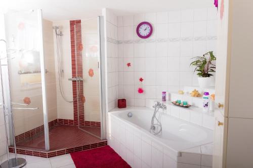ein weißes Bad mit einer Badewanne und einer Dusche in der Unterkunft Crosta Brava in Großdubrau