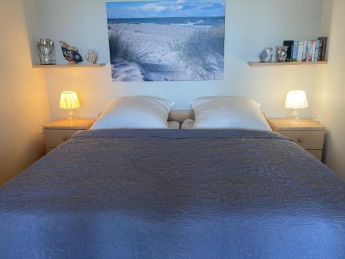 a bedroom with a blue bed with two lamps at Berolina 316 - Möwennest in Dahme