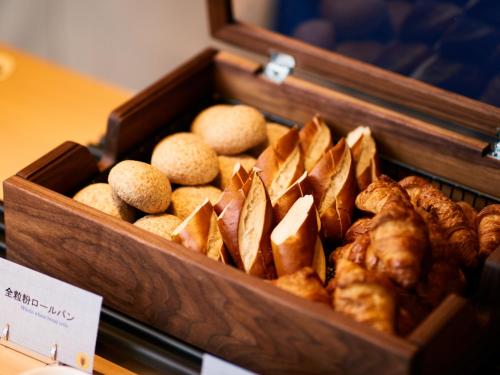 a wooden box filled with different types of bread at Bande Hotel Tenpozan Higashi in Osaka