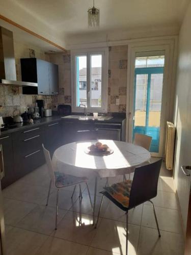 une cuisine avec une table et des chaises dans une pièce dans l'établissement Peaceful room, Thuir centre, view Le Canigou, à Thuir