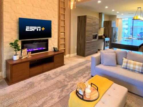 a living room with a couch and a flat screen tv at Premium Home, 7 min from Disney in Orlando