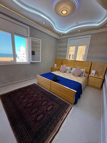 a bedroom with a large bed with a blue blanket at Sea View Apartment in Mirleft
