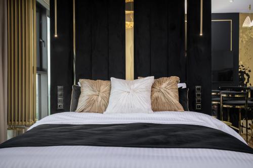 a bedroom with a large bed with pillows at Goldstar Apartament- Wanna z widokiem, 19 Piętro, Hanza Tower Szczecin in Szczecin