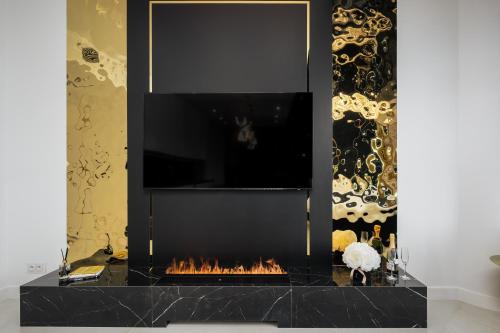 a fireplace with a tv on top of it at Goldstar Apartament- Wanna z widokiem, 19 Piętro, Hanza Tower Szczecin in Szczecin