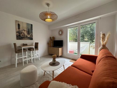 un salon avec un canapé et une table dans l'établissement Cocon proche du centre ville - balcon - parking, à Vannes
