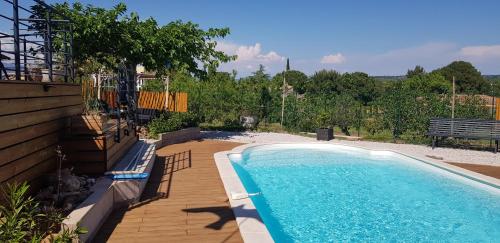 - une piscine dans un jardin avec une terrasse en bois dans l'établissement Villa Palmera - Classée 3 étoiles - Grand confort, calme, et magnifique vue dégagée, à Canet