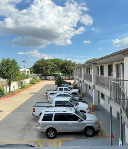 a row of cars parked in a parking lot next to a building at Luxury inn in Houston