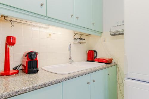 a kitchen counter with a sink and a red appliance at Hidden Pine in Pefkohori