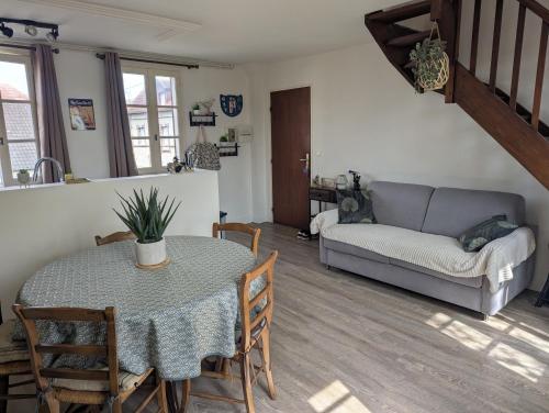 a living room with a table and a couch at Chez Camille in Dives-sur-Mer