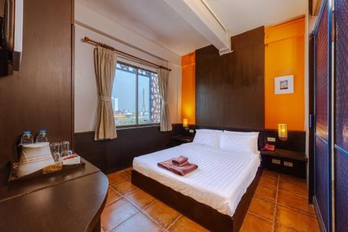 a hotel room with a bed and a window at Diamond House Khaosan in Bangkok