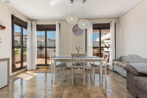 a dining room with a white table and chairs at Golf Hills in Estepona