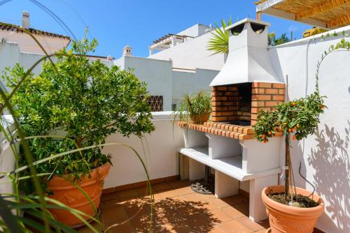 a small balcony with plants and a fireplace at Golf Hills in Estepona
