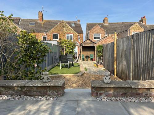 a home with a fence and a backyard with a yard at 57 Southend Road in Hunstanton