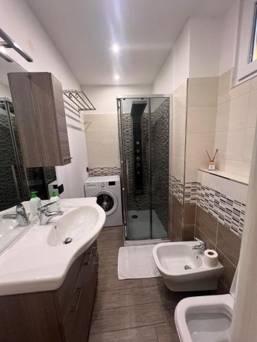 a bathroom with a sink and a toilet and a shower at Casa Concordia, near the station in Bellano