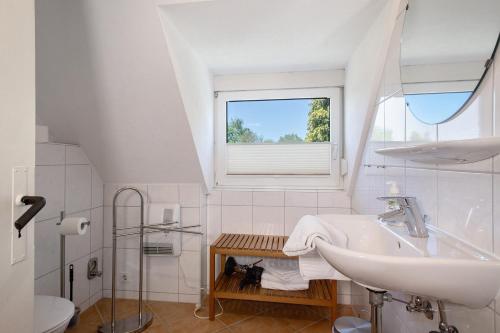 a white bathroom with a sink and a window at Obst- und Ferienhof Lehle in Immenstaad am Bodensee