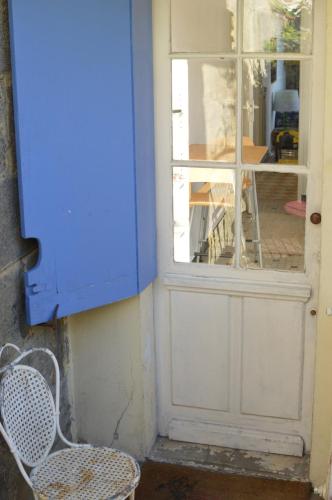a blue door with a chair and a window at Little house with small courtyard in Bordeaux