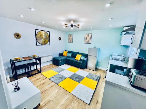 a living room with a blue couch and a table at Luxe 1B Chalet, HotTub, free parking Nr LTN Airport, L&D Hosp, Whipsnade Zoo, fast trains into Central London in Luton
