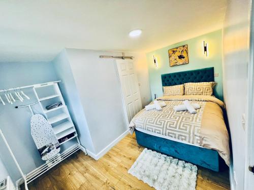 a bedroom with a blue and white bed and a chair at Luxe 1B Chalet, HotTub, free parking Nr LTN Airport, L&D Hosp, Whipsnade Zoo, fast trains into Central London in Luton