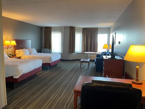 a hotel room with two beds and a couch at SouthShore Hotel on Lake Bemidji, Trademark Coll by Wyndham in Bemidji