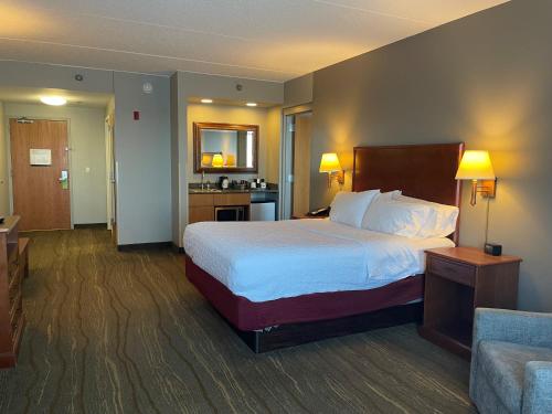a hotel room with a large bed and a couch at SouthShore Hotel on Lake Bemidji, Trademark Coll by Wyndham in Bemidji