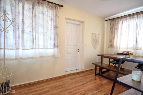 a room with a table and curtains and a desk at Alexandrino in Chios