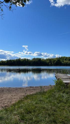 a view of a lake with a wooden dock at Meadow house, a comfortable and modern home near a lake in Ljungby