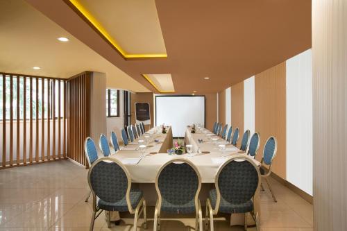 a conference room with a long table and chairs at Horison Ultima Suite & Residences Rasuna Jakarta in Jakarta