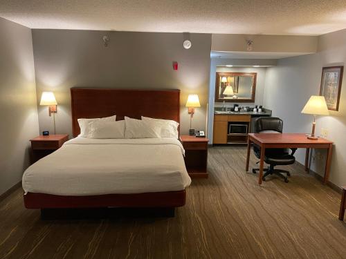 a hotel room with a bed and a desk and a desk at SouthShore Hotel on Lake Bemidji, Trademark Coll by Wyndham in Bemidji