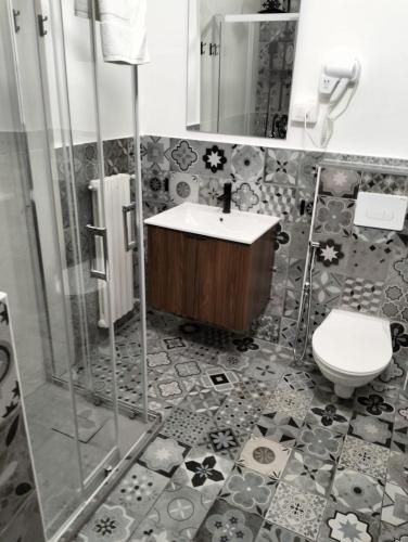 a bathroom with a sink and a toilet at Hotel La Perla in Marina di Massa