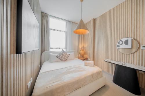 a small bedroom with a bed and a window at Luxury 1BR Apartment near Muweilah Sharjah - Sunny Side up in Sharjah Intl