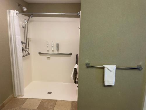a bathroom with a shower and a white towel at SouthShore Hotel on Lake Bemidji, Trademark Coll by Wyndham in Bemidji