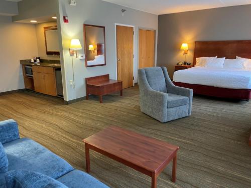 a hotel room with a bed and a couch and a table at SouthShore Hotel on Lake Bemidji, Trademark Coll by Wyndham in Bemidji