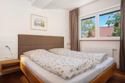 a bed in a bedroom with a large window at Obst- und Ferienhof Lehle in Immenstaad am Bodensee