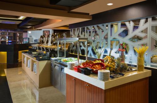 a kitchen with a counter with fruits and vegetables on it at Horison Ultima Suite & Residences Rasuna Jakarta in Jakarta