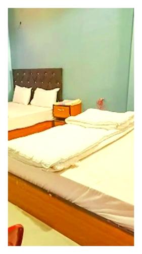 two twin beds sitting next to each other in a room at Prem Ji Aanand Hotel and Restaurant in Phata