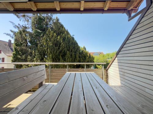 a wooden picnic table on a balcony with trees at Obst- und Ferienhof Lehle in Immenstaad am Bodensee