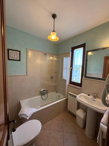 a bathroom with a tub and a toilet and a sink at Posada Soano in Soano