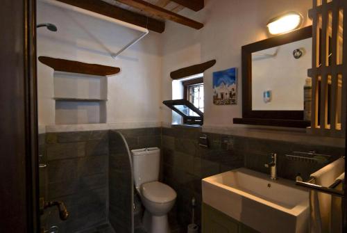W łazience znajduje się toaleta, umywalka i lustro. w obiekcie Great Pelion Villa Villa Stone House 2 Bedrooms Sea View Aghios Georgios w mieście Pilion