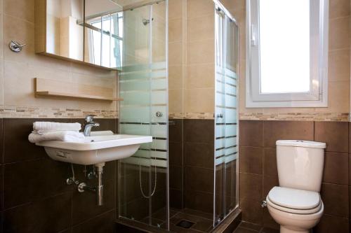 W łazience znajduje się toaleta, umywalka i lustro. w obiekcie Deluxe Kefalonia Apartment Apartment Neroli 2 Bedroom Pool Karavomilos w mieście Karavomylos