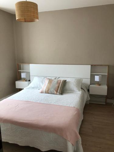 a bedroom with a large bed with two night stands at Casa Belia in Mansilla de las Mulas