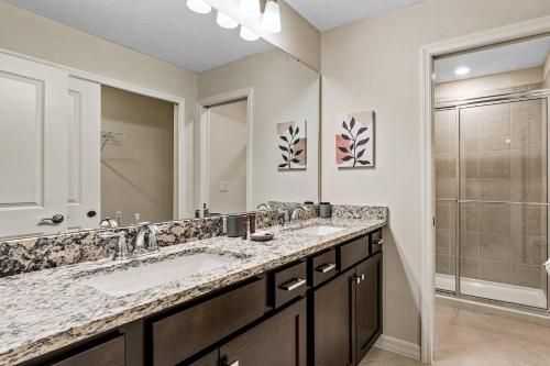 a bathroom with two sinks and a shower at Brand New Charming Home 9 Miles To Disney in Orlando
