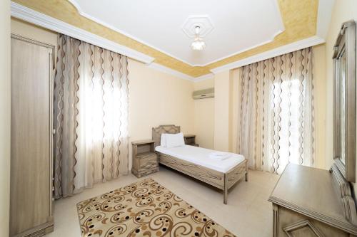 a bedroom with a bed and a table and a window at Avsallar Kepenek Village in Avsallar