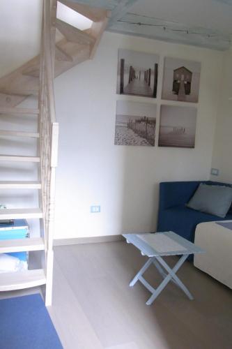 a living room with a blue couch and a staircase at Torre marina in Riomaggiore