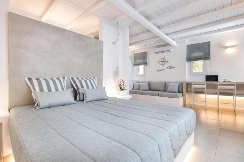 une chambre avec un grand lit et un canapé dans l'établissement Luxury Paros Villa 1 Bedroom The Cobble Suite Private Jacuzzi & Private Terrace Naousa, à Kampos Paros