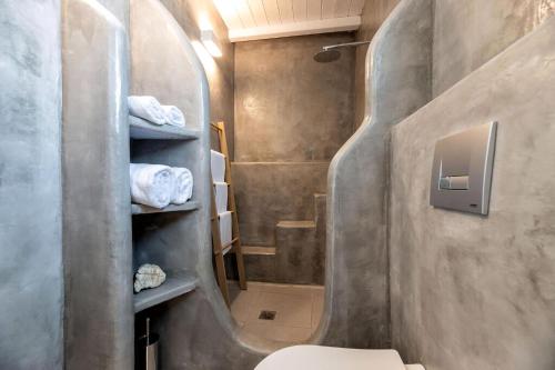 La salle de bains est pourvue de toilettes, d'une douche et de serviettes. dans l'établissement Luxury Paros Villa 1 Bedroom The Cobble Suite Private Jacuzzi & Private Terrace Naousa, à Kampos Paros