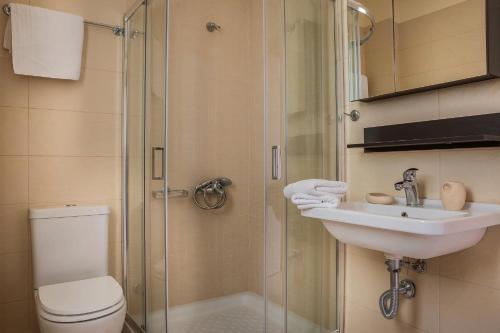 a bathroom with a toilet and a sink and a shower at Deluxe Kefalonia Apartment Apartment Perla 1 Bedroom Pool Sea View Karavomilos in Karavomylos